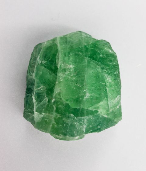 Green emerald gemstone on a light background