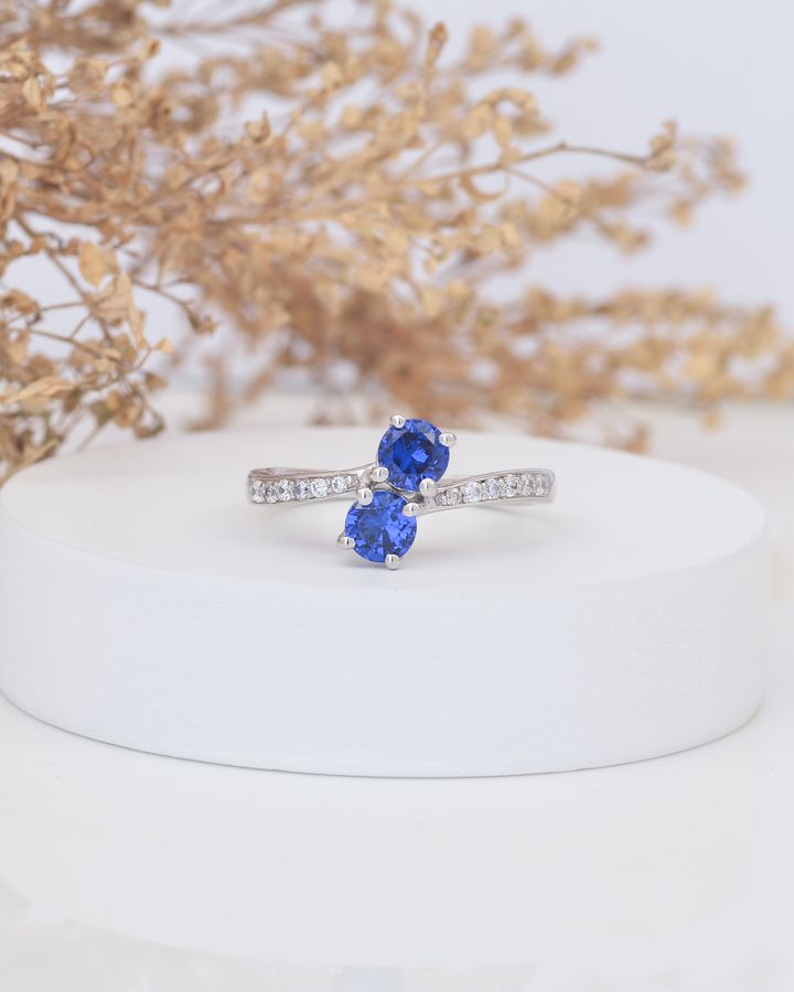 Sapphire and diamond engagement ring on a minimalist display